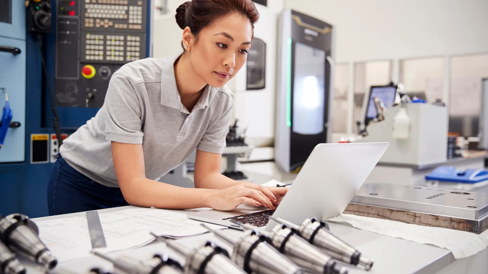 Engineer working beside manufacturing equipment